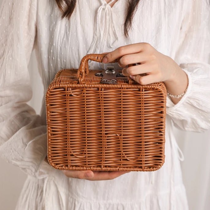 woman in white dress holding faux rattan basket by the handle