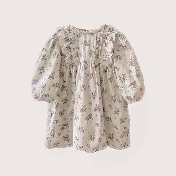 Vintage girls autumn dress in floral print with oversized sleeves displayed on a beige background.