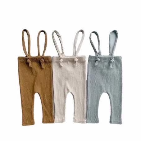 Three pairs of baby suspenders made from rib cotton on a white background. They are stretchy and come in three colours: dusty blue, cream and khaki.