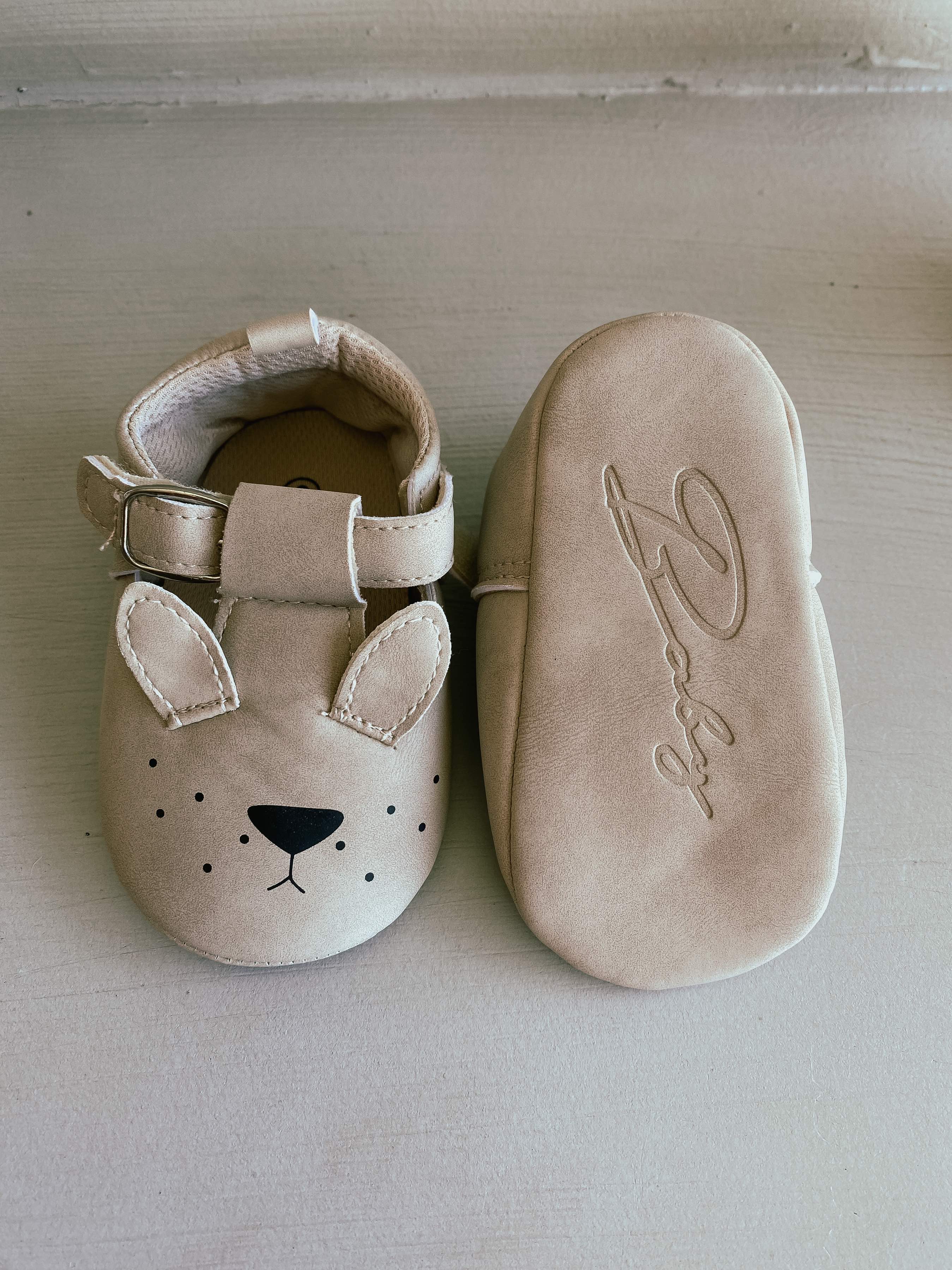 picture of baby booties with t-bar design. one is turned upside down to show the full design of the pram shoes with bunny face.