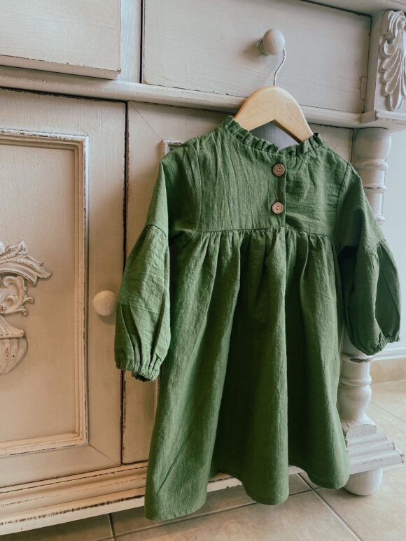 back of dark green linen dress showing wooden buttons and frilly collar.