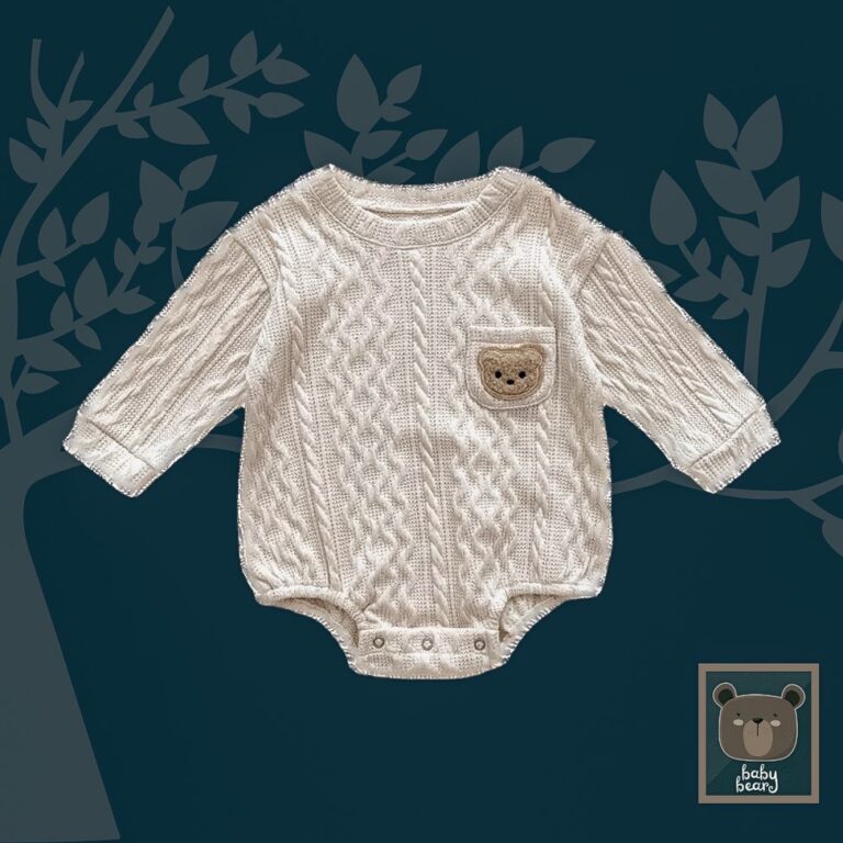 White cotton baby romper with patterned detail in the stitching. The romper is displayed on a navy blue background with tree detail and the official baby owl baby bear collection logo in the bottom right hand corner of the image. The romper has a pocket on right side of chest which has a teddy transfer on it.