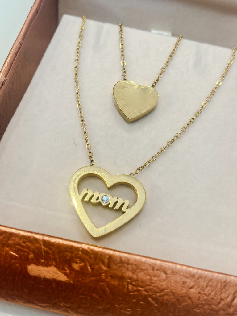 mom necklace with two chains. oNE WITH SOLID GOLD HEART AD THE OTHER WITH MOM WRITTEN IN THE HEART WITH STONE DETAIL. PRESNTED IN GIFT BOX